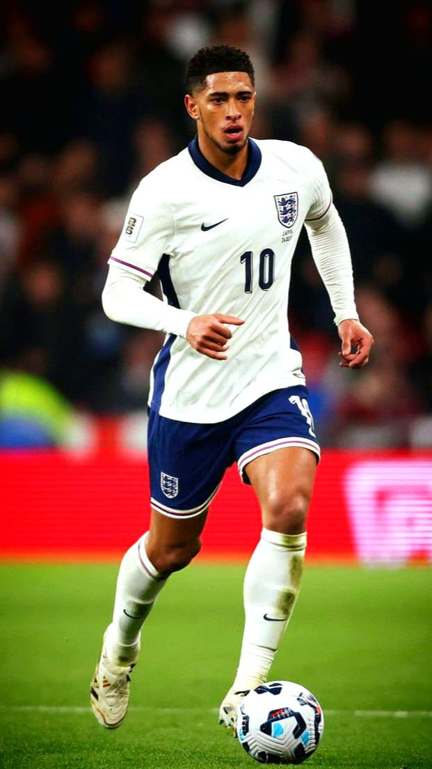 An England football player wearing a white jersey with the number 10 dribbles a soccer ball on the field during a match, as fans watch the action live on Malta IPTV.